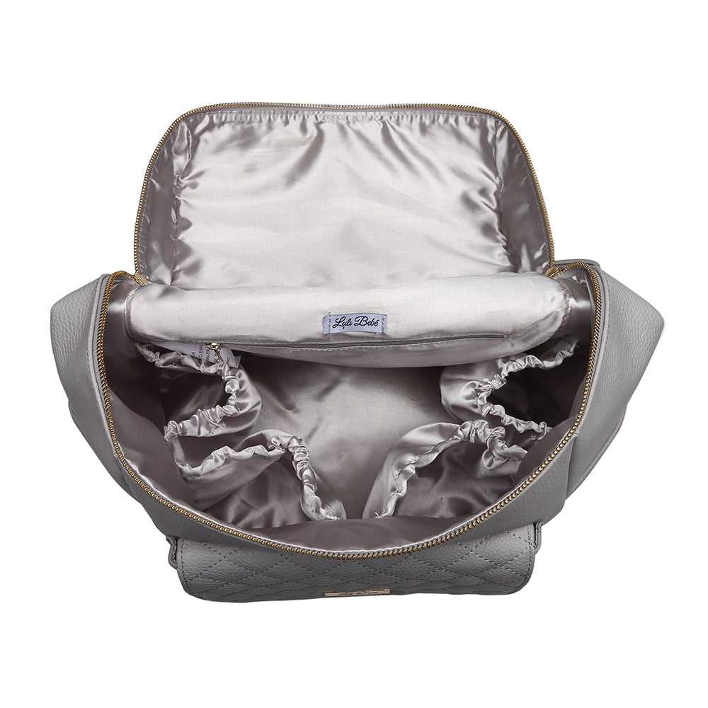 Gray backpack with a pillow and baby blanket inside on a white background