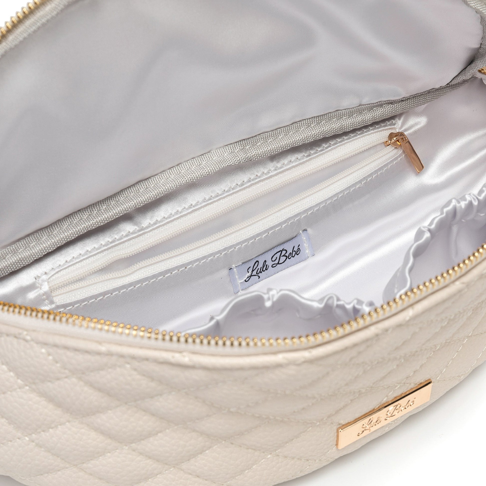 Close-up of a beige quilted handbag with gold zipper and 'Lulu & Bello' label.