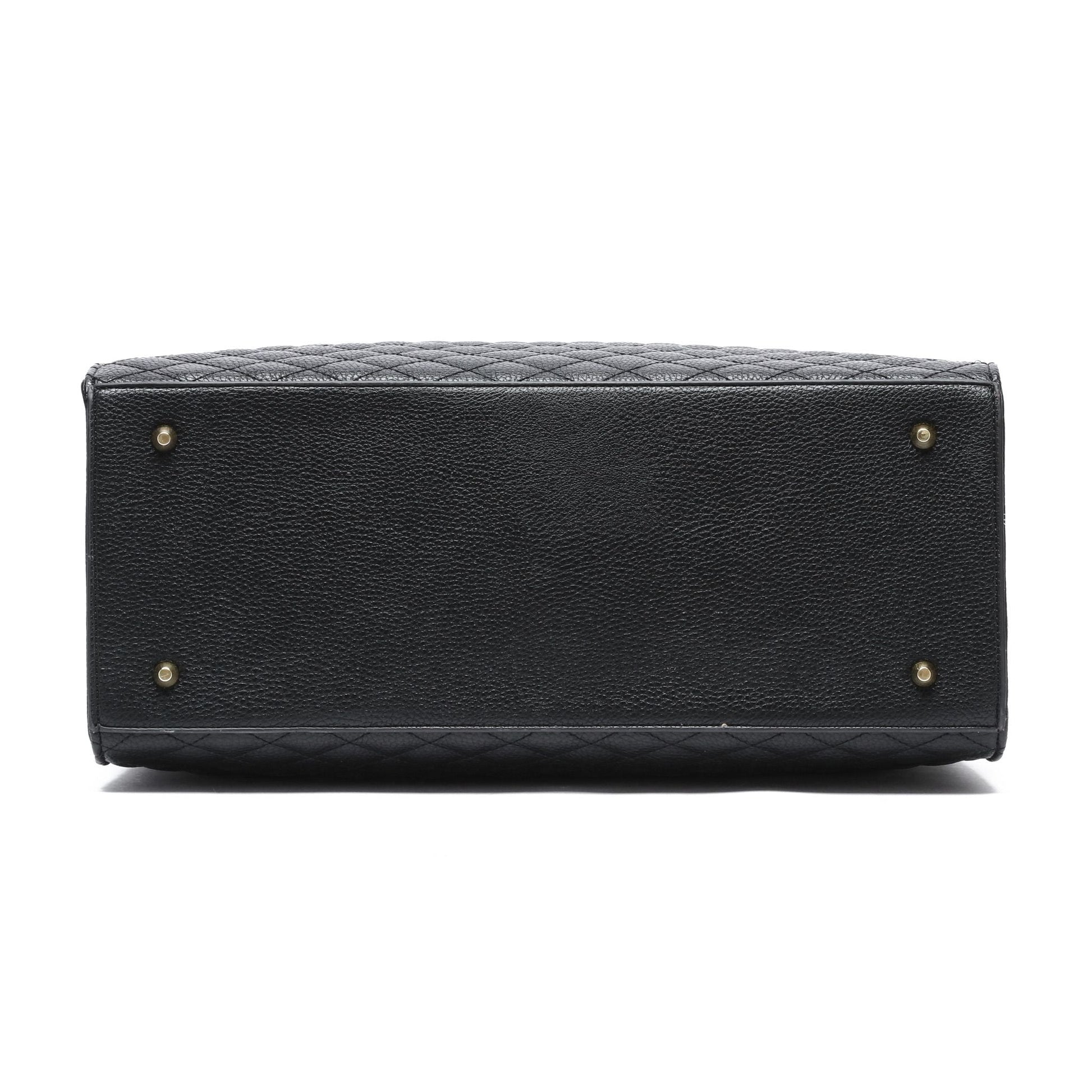 Black quilted handbag with gold hardware on a white background