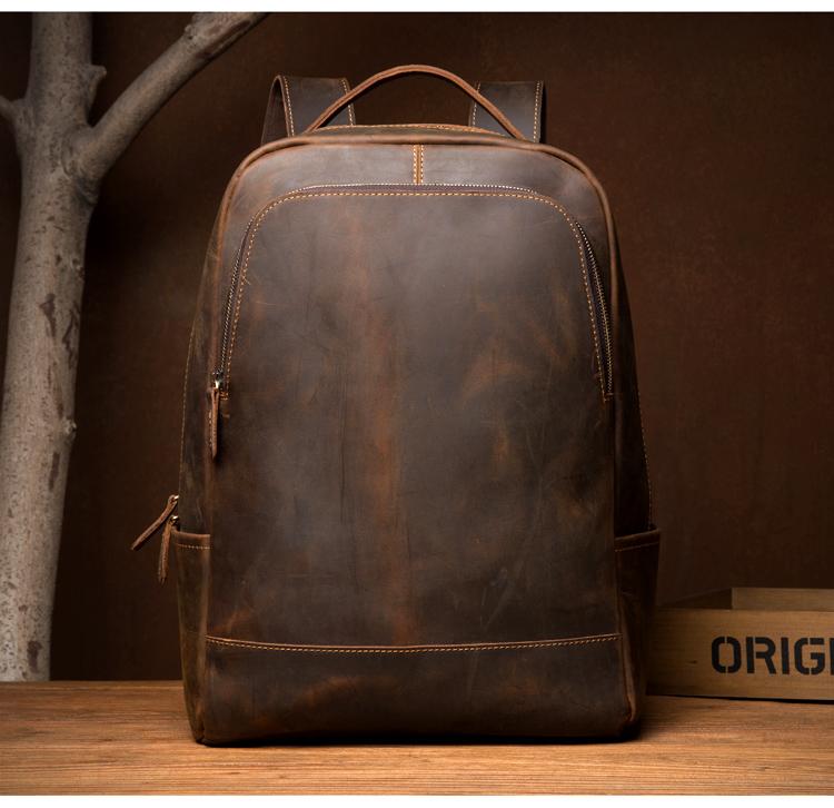 Brown leather backpack on a wooden surface with a dark brown background