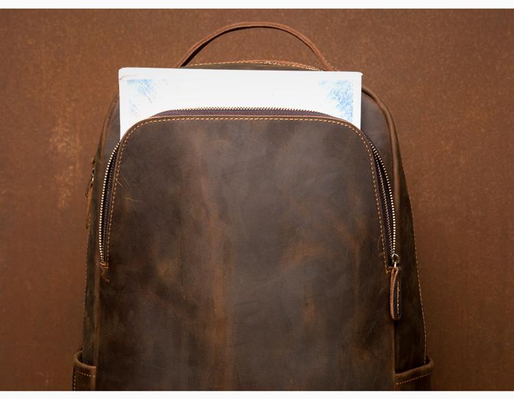 Brown leather backpack with a zipper on a brown background